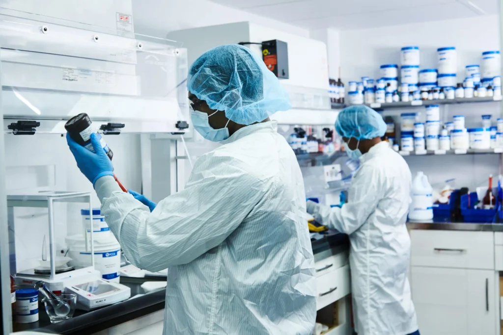Scientists in protective gear working in a laboratory.